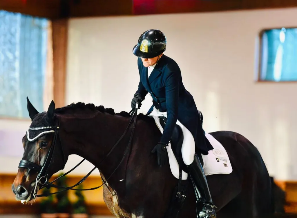 Cavaliere in sella durante una sessione di allenamento dressage indoor