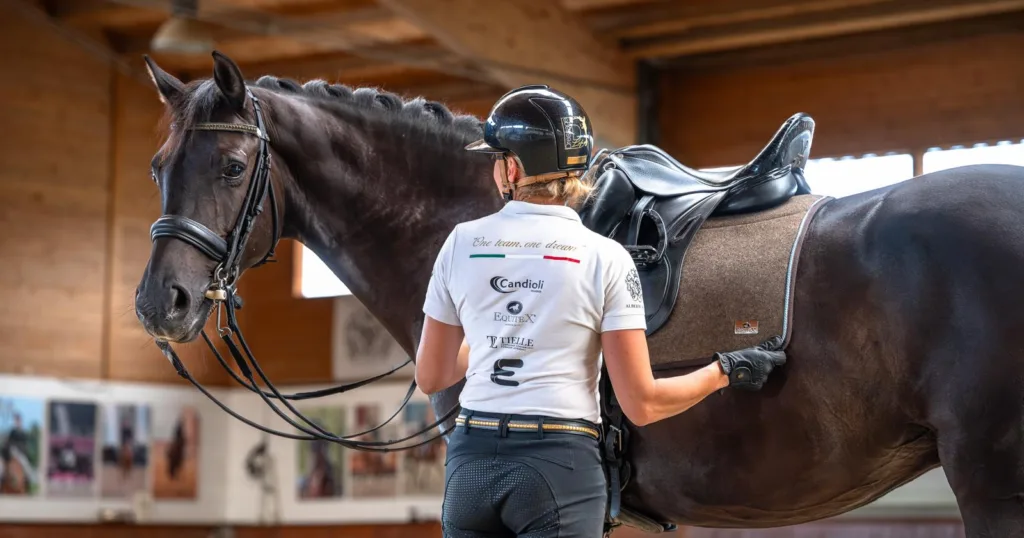 Cavaliere accanto al cavallo durante un momento di preparazione e relazione